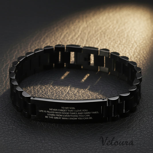 Black metal bracelet with engraved text on a world map background