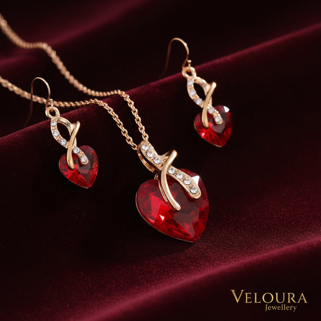 Jewelry set with red heart-shaped pendants and gold accents on a white background
