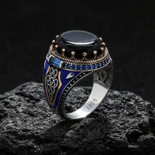 Decorative ring with black stone and blue accents on a white background